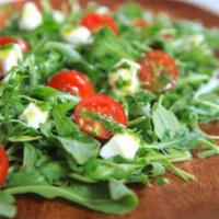Caprese salad  · Fresh mozzarella, cherry tomato, arugula, basil parmesan. Comes with champagne vinaigrette w...