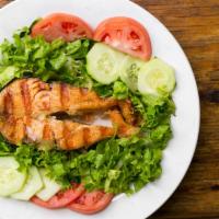 Grilled Salmon Salad · Fresh salmon on a bed of lettuce, tomato, and carrot.