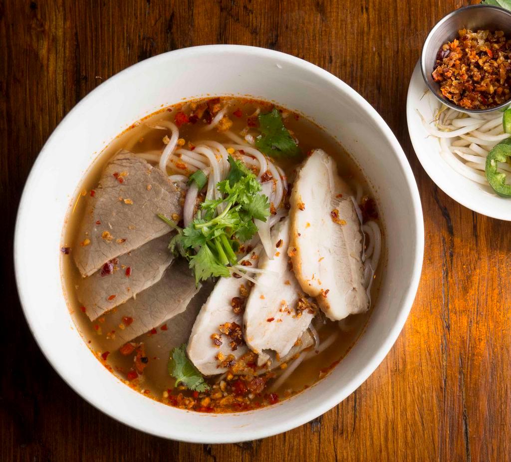 Bun Bo Hue · spicy lemongrass broth, braised pork belly, beef brisket, red onion, cilantro, and round rice noodles served with side of bean sprouts, and crusted chili garlic jalapeno, and lime wedge