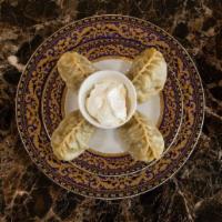 Manti (4 pieces) · Traditional dumpling with spiced meat mixture, onions, boiled or steamed.