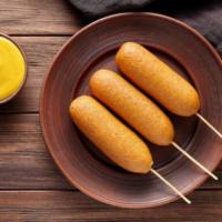 Corn Dog · A plump, juicy hot dog on a stick, breaded and deep-fried.