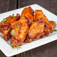 Chicken Wings · Crispy fried chicken wings tossed in your choice of signature sauce, Henny chipotle BBQ, lem...