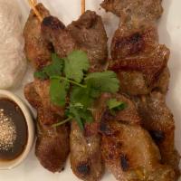 Moo Ping · Grilled marinated pork served with sticky rice and Thai style sauce.