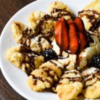 Banana Fritters a la Mode · Fresh bananas, lightly battered and fried. Served with vanilla ice cream topped with chocola...