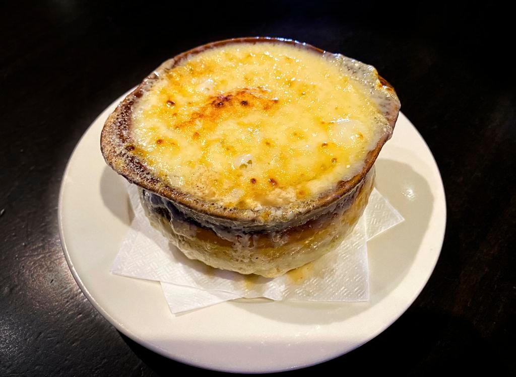 French Onion Soup · Our take on this classic is made with caramelized onions topped with baguette and covered with melted Gruyere (contains a trace amount of alcohol).