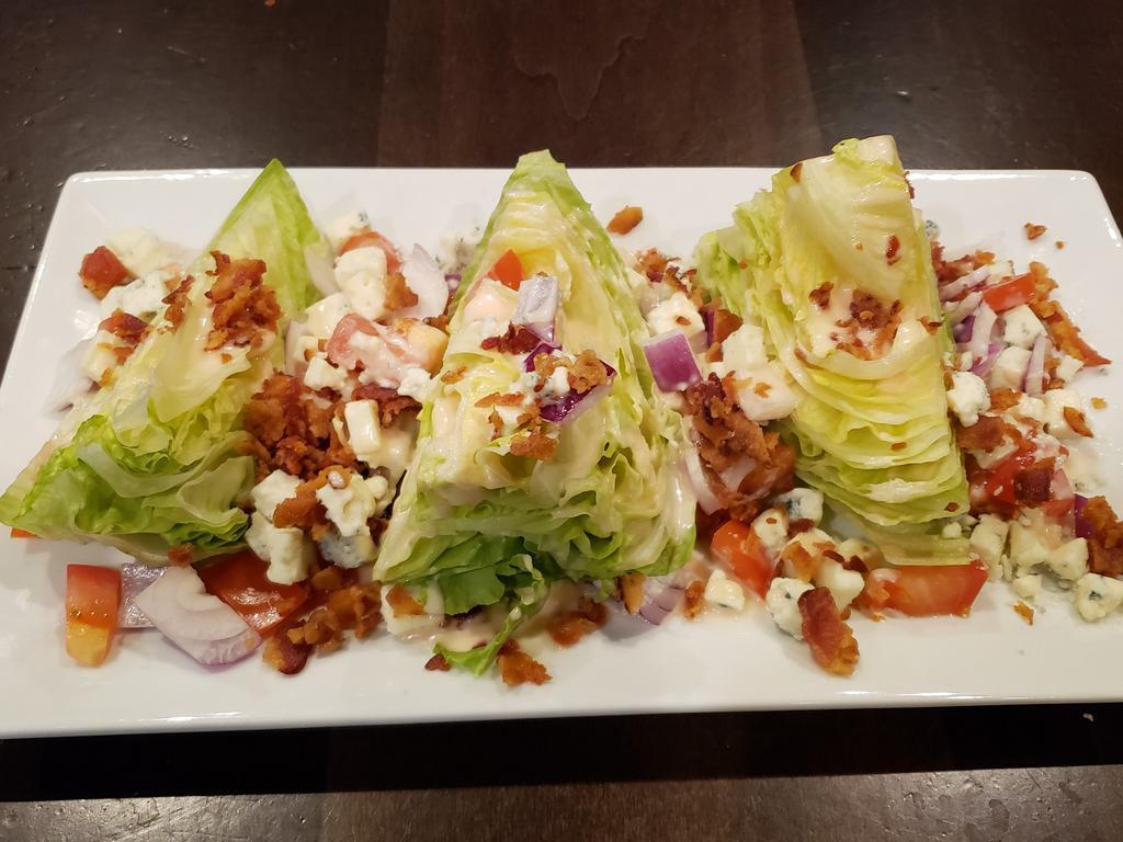 Wedge Salad · Gluten free. Iceberg lettuce with chunky blue cheese crumbles, crispy bacon, red onions and diced tomatoes dressed with our house made vinaigrette. Add ons available for an additional charge.