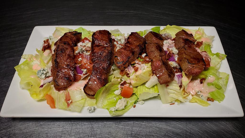 Steak GF · Ribeye steak cooked to your liking served over our signature mix of romaine and iceberg, with chunky blue cheese crumbles, crispy bacon, red onions and diced tomatoes dressed with our house made vinaigrette.