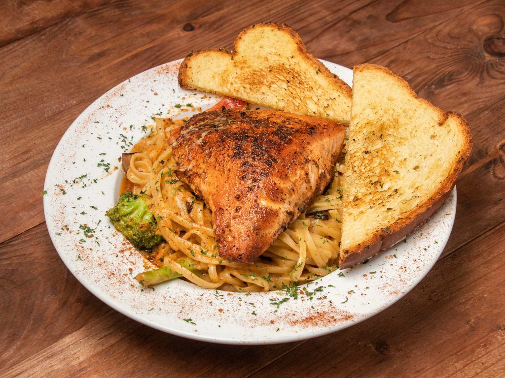 Blackened salmon pasta · Pan seared blackened over linguine pasta tossed in a cajun cream sauce with peppers, onions, and broccoli.
