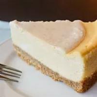 Vanilla Bean Cheesecake Slice · Creamy and dense handmade vanilla cheesecake on top of a butter graham cracker crust.