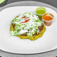 Sope · A round thick homemade corn tortilla, topped with refried beans, choice of meat, lettuce, to...