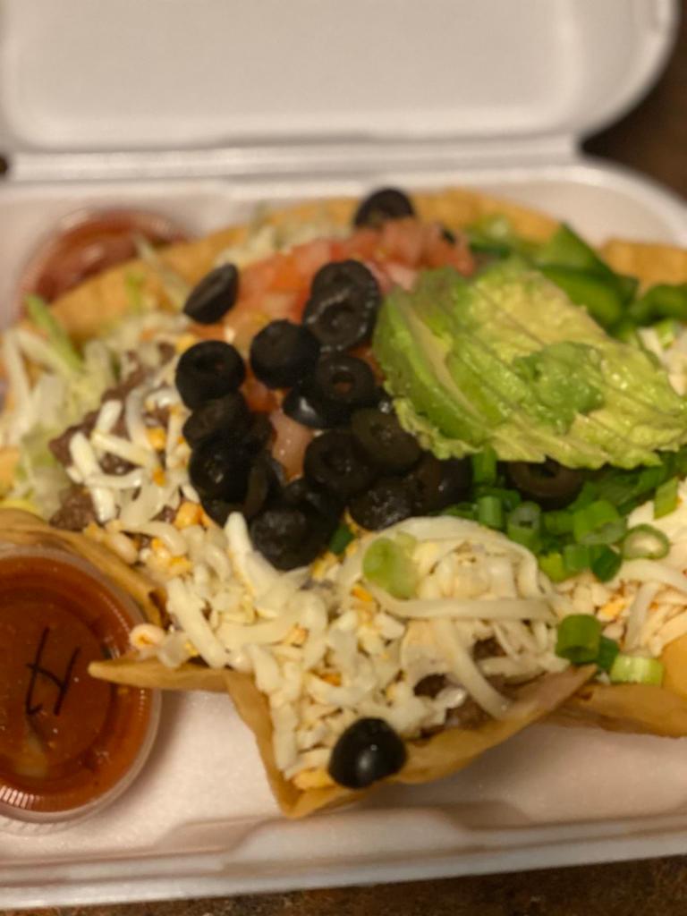 Ground Beef Taco Salad · Crisp flour shell filled with refried beans, lettuce and ground beef. Topped with shredded cheese, chopped tomato, green pepper, black olives, green onion, sour cream and avocado.