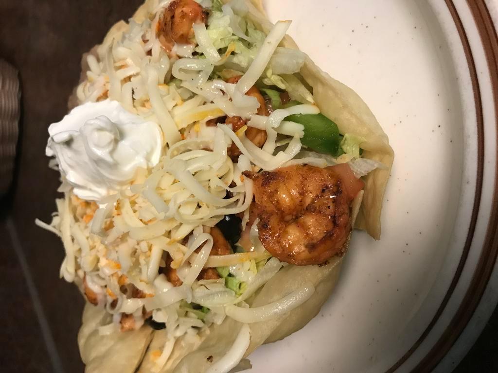 Grilled Shrimp Taco Salad · Crisp flour shell filled with refried beans, lettuce, shredded cheese, grilled shrimp, tomato, green pepper, avocado, green onion, black olive and sour cream.