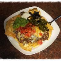 Small Burger Nacho · Corn chips covered with ground beef and melted cheese. Topped with sour cream, guacamole, to...