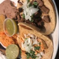 Tacos al Carbon Dinner · 3 soft corn tortillas filled with choice of grilled steak or chicken. Topped with diced cila...
