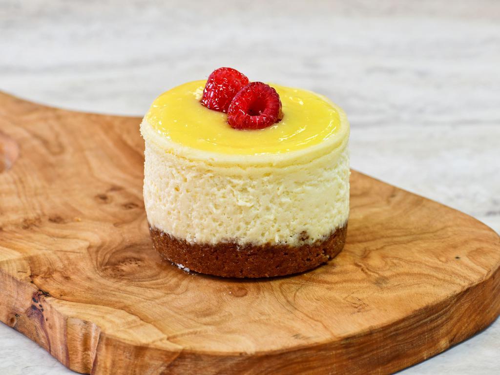 Lemon (Puckered Up) Cheesecake · A luscious lemon filling with a zesty lemon curd topping, finished with candied lemon slices.