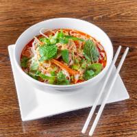Kao Poon · Red curry and coconut milk with vermicelli noodles and chicken. Topped with mint, shredded c...