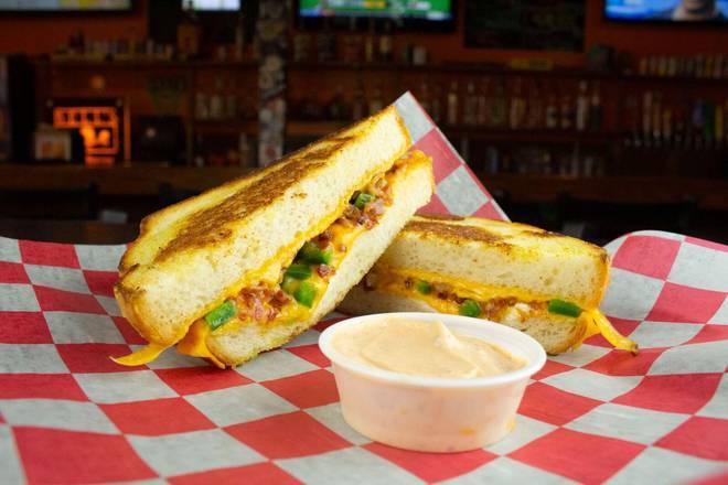 The Popper · Cheddar cheese, cream cheese, cheddar cheese sauce, fresh jalapeño slices and bacon on sourdough bread. Served w/ chipotle mayo dipping sauce.