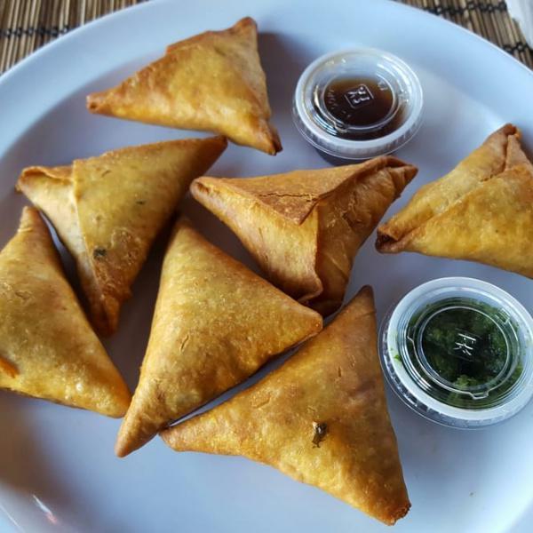 Sambusas 7 · A savory pastry enjoyed across Africa, delicately spiced with exotic flavors. Spicy beef, chicken, spicy lentil, potato, spinach, cream cheese, coconut and shrimp.