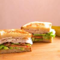 Turkey Club · Oven roasted turkey breast on grilled sourdough with melted Swiss, bacon, lettuce, tomato, a...