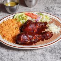Pollo en Mole · Servido con ensalada, arroz y frijoles. Chicken in a mole sauce, served with salad, rice, be...
