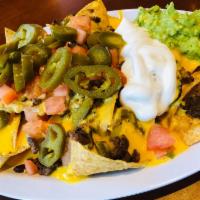 Steak Nachos · Served with beans, cheese, tomato, jalapeños , guacamole and sour cream.