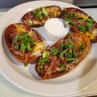 Potato Skins · Scooped out Idaho potatoes loaded with cheese, tomatoes, green onions and bacon.