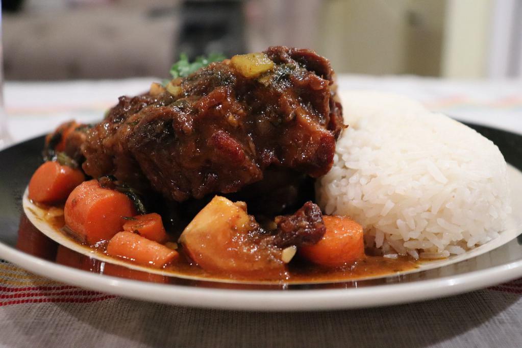 Stewed Oxtails Platter · Oxtails marinated in herbs and spices served with carrots, red beans. Served with your choice of rice and veggies.  Platter comes with plantains (5). 

Your choice: 
Basmati (white) rice or peas and rice
Stewed Spinach or stewed cabbage