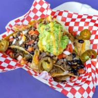Loaded Nachos · Home made Corn tortillas chips, ground beef, cilantro, onions, black beans, guacamole, spicy...