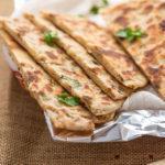 114. Onion Kulcha · Layered bread stuffed with onion and herbs and baked in day oven.