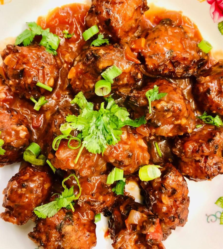 Chicken Manchurian · Flour mixed with tomato, onion and special spices and sauces. Served fried. Served with sauce and rice.