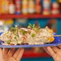 Elote · Mexican street corn served with roasted garlic, jalapeno mayo, chili powder, tajin, queso co...