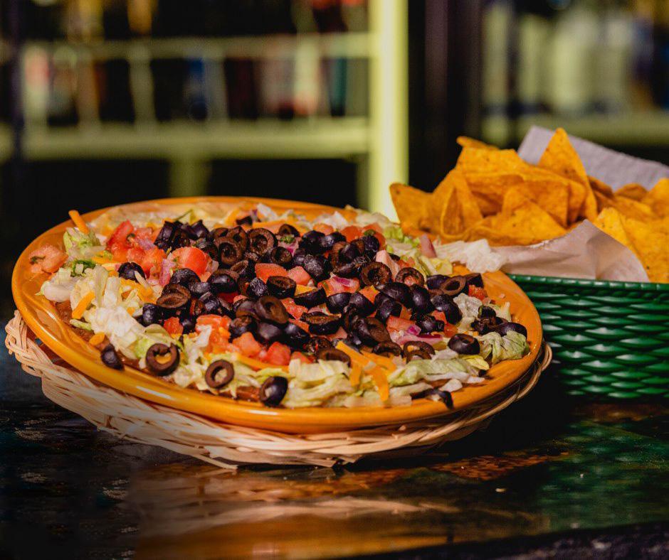 7 Layer Dip · A generous portion of refried beans layered with queso dip, jalapeno cream cheese, lettuce, shredded cheese, pico and black olives. Add extras for an additional charge.