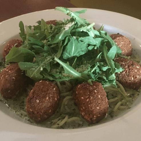 Arugula Pesto Pasta · Spaghetti pasta in a creamy pesto sauce, garnished with arugula. Served with your choice of chicken or falafel nuggets.
