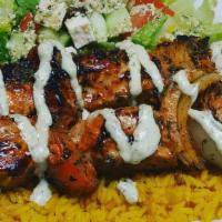 Greek Chicken Souvlaki · Two skewers of marinated and grilled chicken breast topped with lemon garlic aioli over rice...
