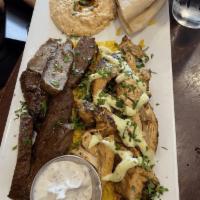 Middle Eastern Combo Platter · Gyros and chicken thighs over rice pilaf. Served with Greek salad, hummus, tzatziki and pita...