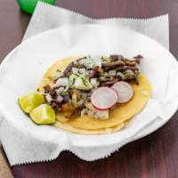 Al Pastor Taco · Soft tortilla filled with Al Pastor and topped with onions and cilantro, served with lime on...