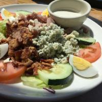 Cobb Salad · Crisp greens, roasted turkey breast, bacon, ham, bleu cheese crumbles, tomato, cucumber, har...