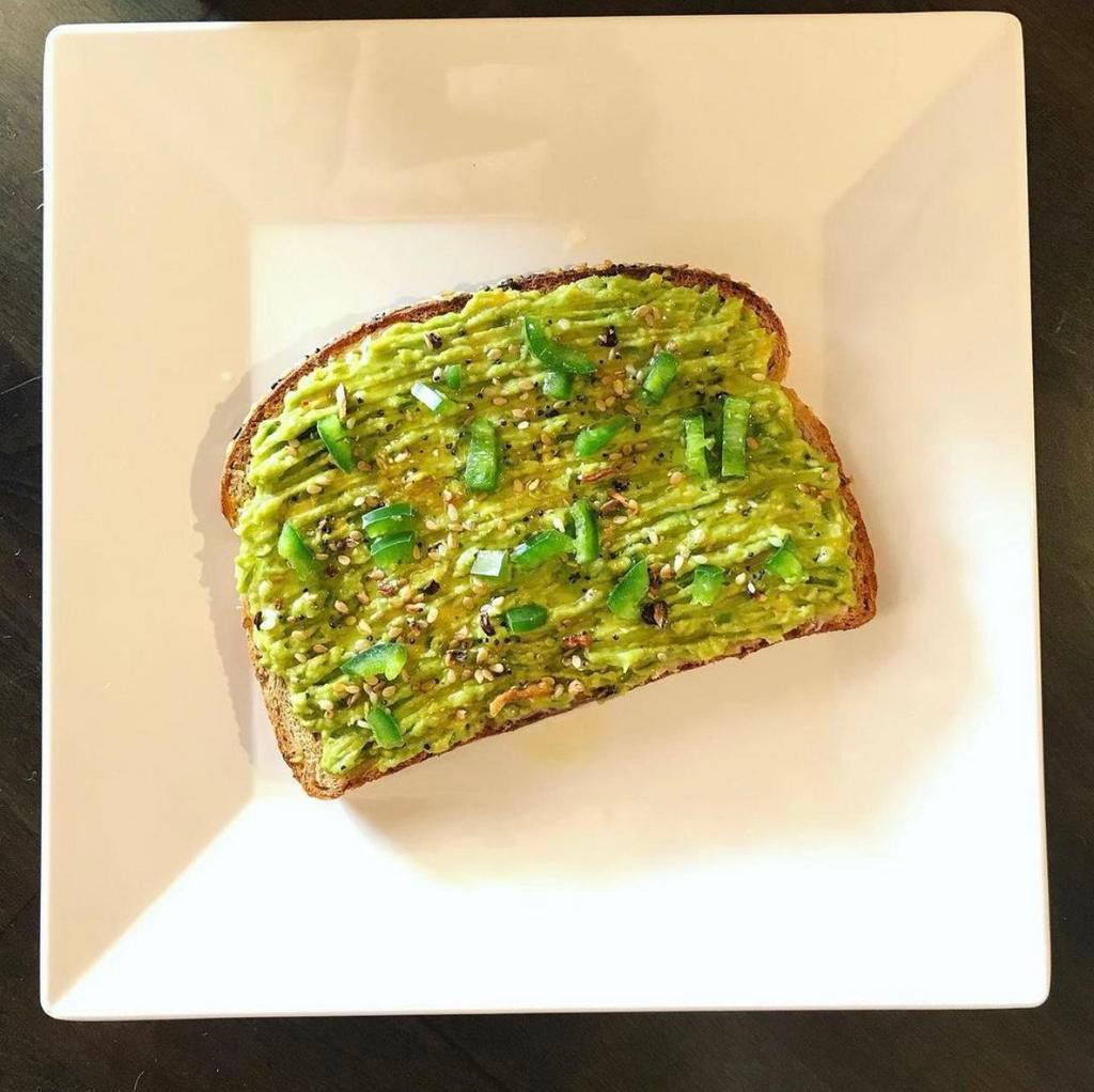 Avocado Toast · Sourdough toast topped with freshly mashed avocado, lemon, basil, and sprouts. Drizzled with olive oil.