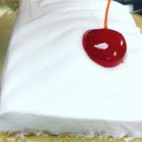 Tres Leches (Box Container) · Vanilla Cake soaked in three milks with a whipped cream frosting and a maraschino cherry on ...