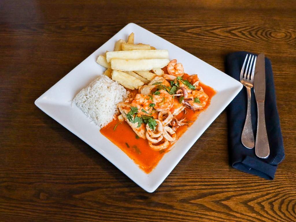 Mahi a Lo Macho · Pan-seared mahi-mahi with spicy calamari and shrimp sauce served with rice and yuca fries.