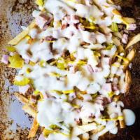 El Cubanito Fries · Roasted pulled pork, cured ham, pickles, melted swiss, garlic mojo and a mango mustard drizz...