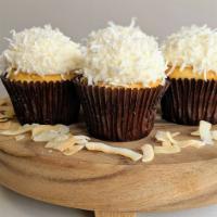 Coconut Cake · Our vanilla bean cake with coconut cream cheese frosting and topped with coconuts!