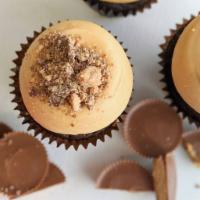 Peanut Butter Cup Cake · A classic chocolate cake topped with our peanut butter cream cheese icing and crumbled Reese...