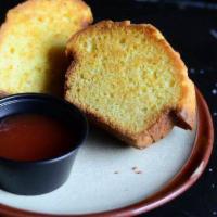CORN MUFFIN · fresh baked corn muffin split in half and griddled with butter. Served with house made guava...