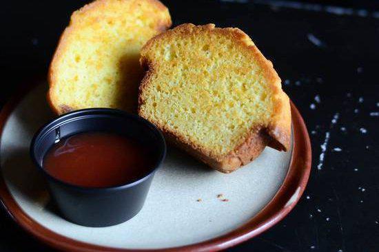 CORN MUFFIN · fresh baked corn muffin split in half and griddled with butter. Served with house made guava jelly on the side.