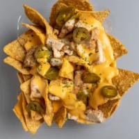 Chicken Nachos · Nacho cheese, lettuce, tomatoes, jalapeño peppers, sour cream
