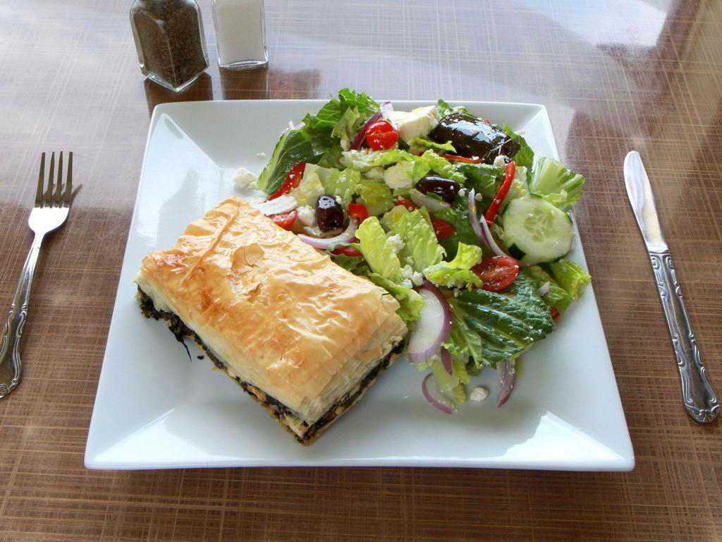 Greek Salad · Romaine lettuce, tomatoes, cucumbers, olives red onion, feta cheese, anchovies and grape leaves, served with toasted pita bread.