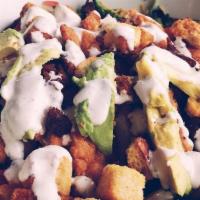 Crispy Chicken Salad* · Hand breaded chicken tenders on top of a bed of mixed greens with bacon, avocado, tomatoes, ...