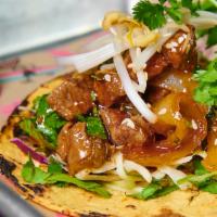 Korean BBQ Taco · Korean BBQ glazed grilled steak, caramelized onion, Asian slaw and toasted sesame seeds. Ser...