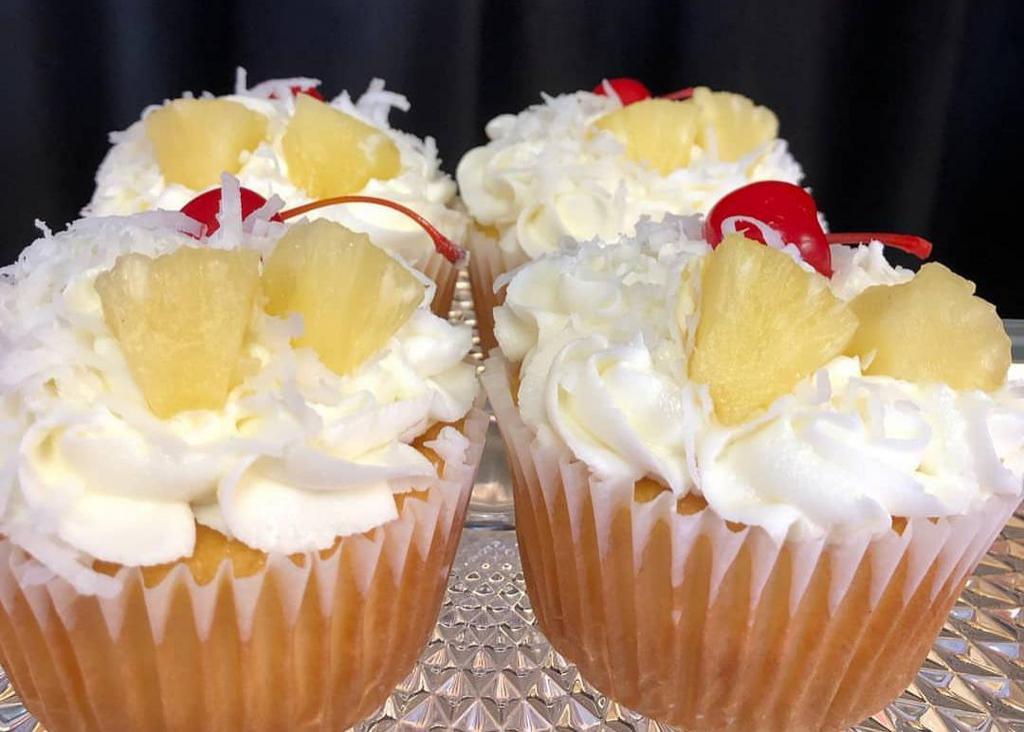 Pina colada  · Moist pineapple cake topped with buttercream icing, sweet coconut, fresh pineapple and a maraschino cherry.